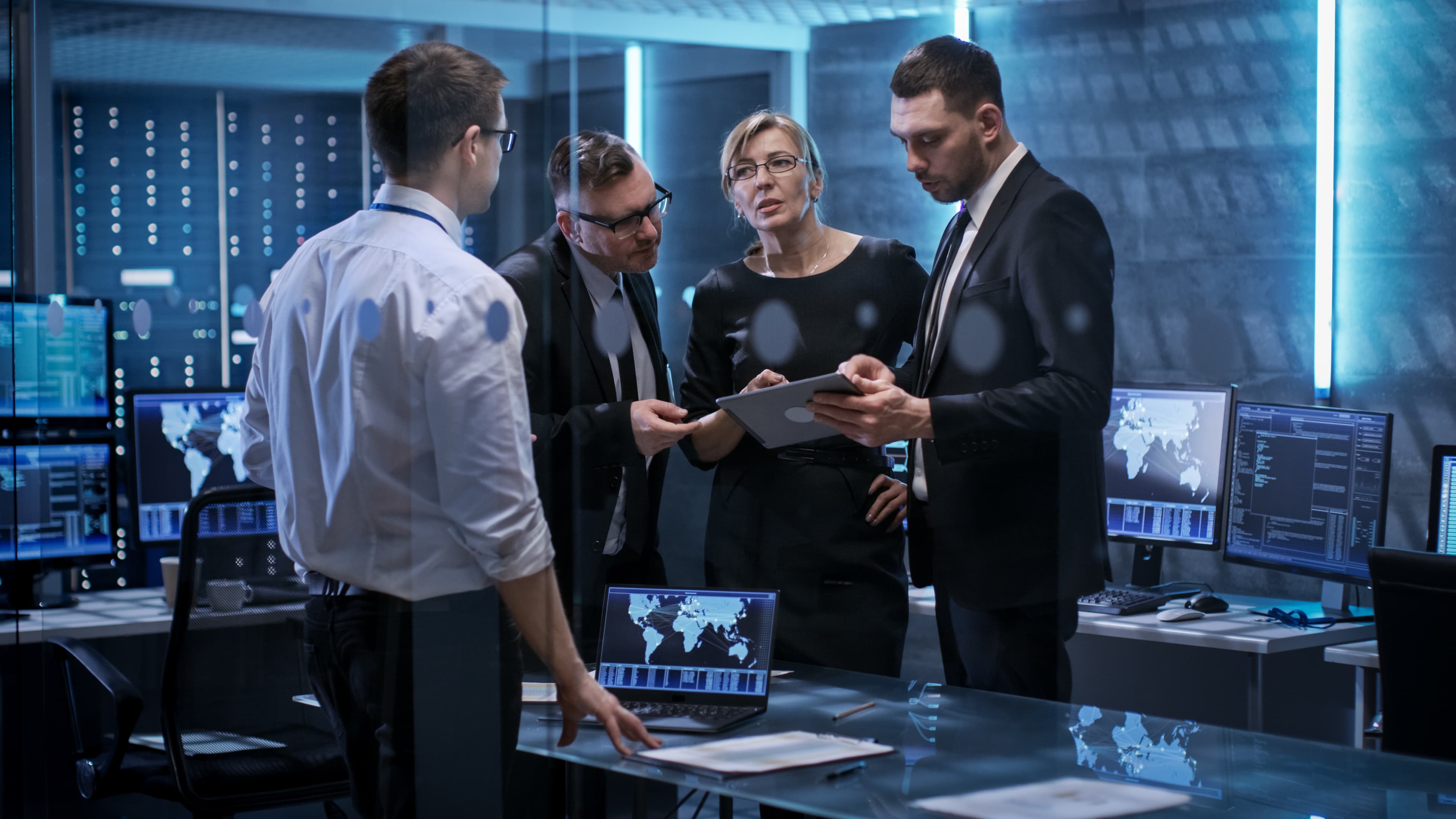 Professionals bekijken netwerkdata op tablet en groot scherm