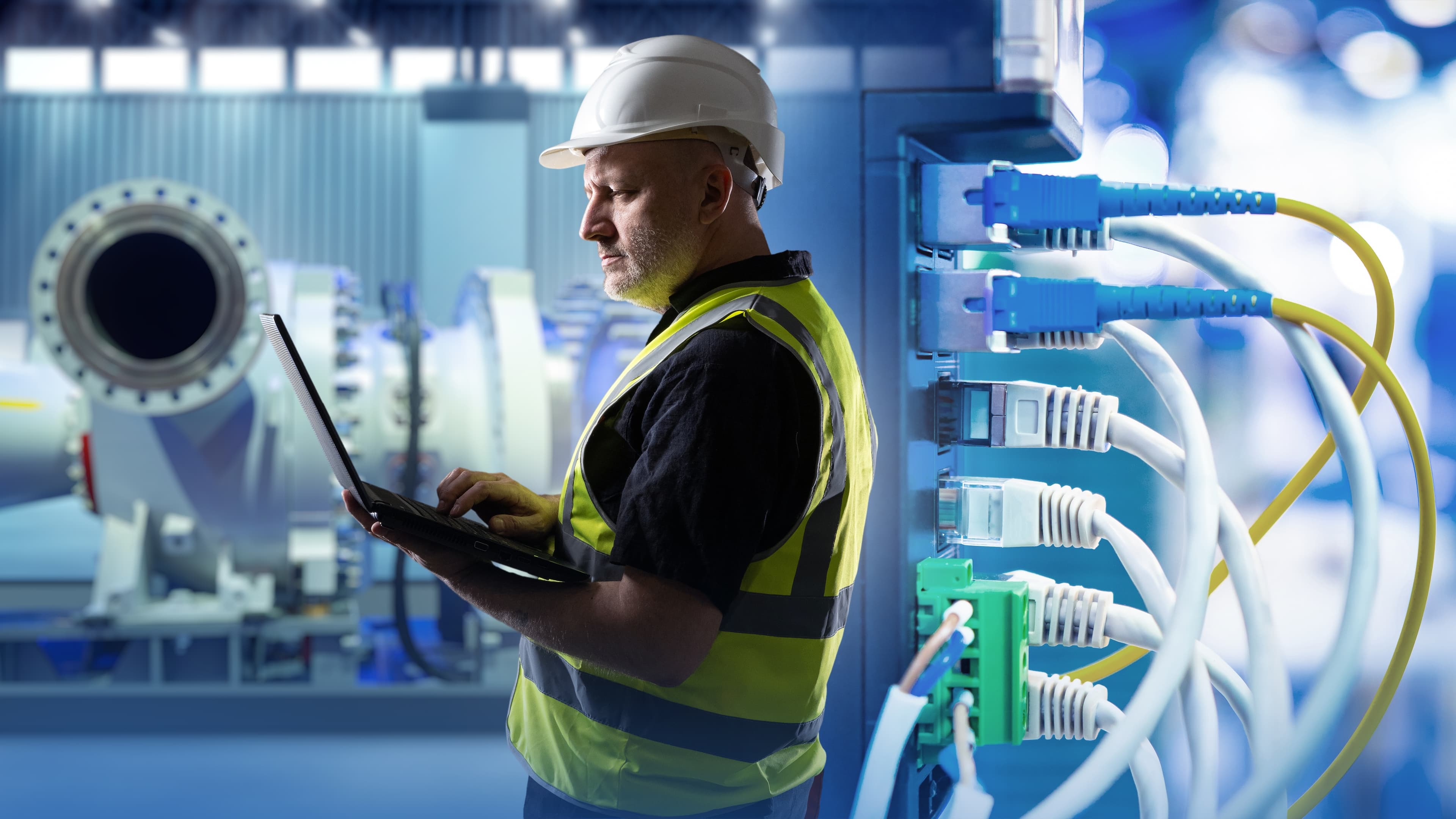 Technicus monitort netwerkapparatuur in industriële omgeving