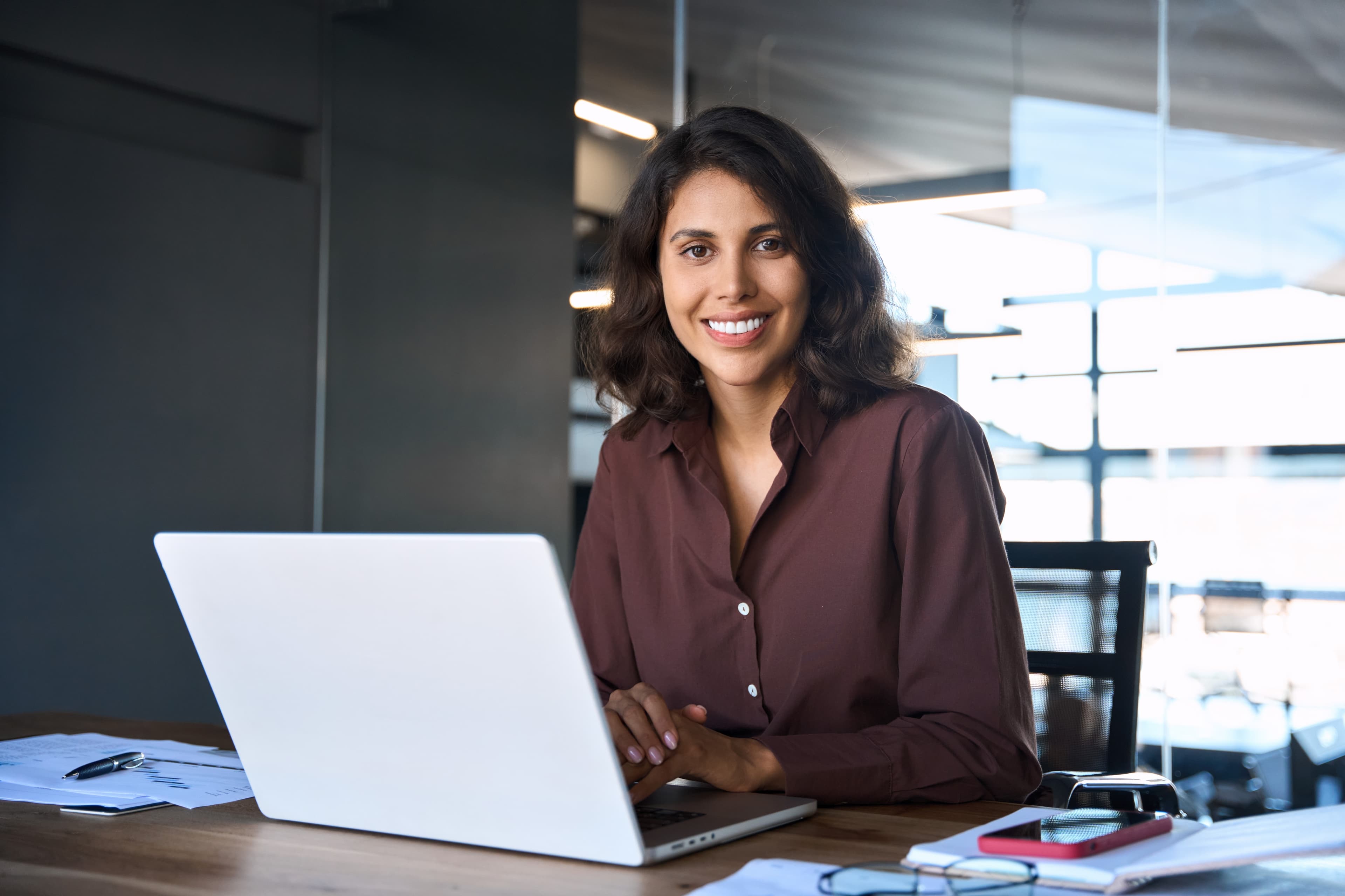 Vrouw aan bureau met laptop in kantooromgeving