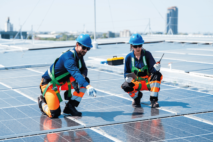 Technicians working on solar panels on a roof